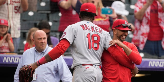 El jardinero derecho de los St. Louis Cardinals, Jordan Walker, abraza al manager Oliver Marmol después de la victoria del equipo sobre los Colorado Rockies, el miércoles 12 de abril de 2023, en Denver.