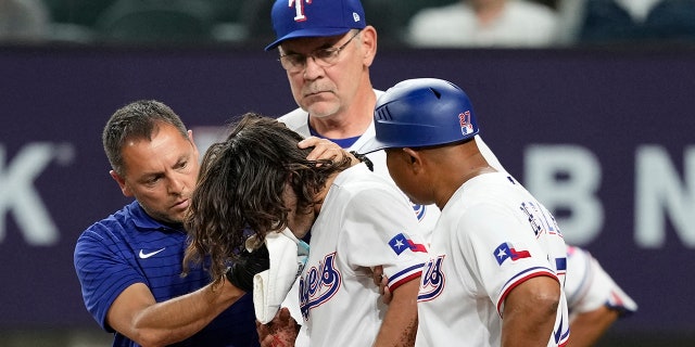 Apr 3, 2023; Arlington, Texas, USA; Texas Rangers left fielder Josh Smith (47) leaves the game after getting hit by a pitch thrown by Baltimore Orioles relief pitcher Danny Coulombe (not shown) during the third inning at Globe Life Field.