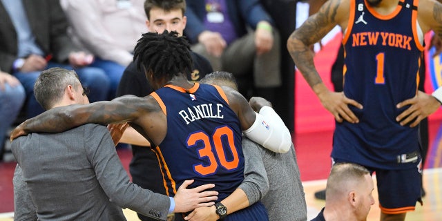 Julius Randle is helped off the court