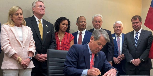Georgia Gov. Brian Kemp signs into law a bill aimed at making public schools safer during a ceremony in Savannah, Georgia, on Thursday, April 13, 2023.