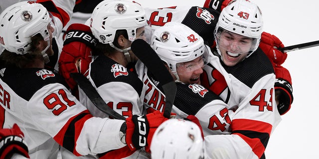 New Jersey Devils defenseman Luke Hughes, right, celebrates with teammates after his winning goal in overtime against the Capitals, Thursday, April 13, 2023, in Washington.