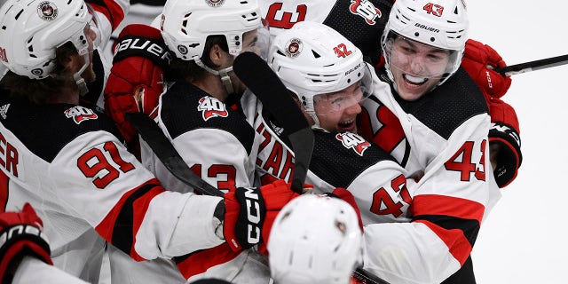 New Jersey Devils defenseman Luke Hughes, right, celebrates with teammates after his winning goal in overtime against the Capitals, Thursday, April 13, 2023, in Washington.