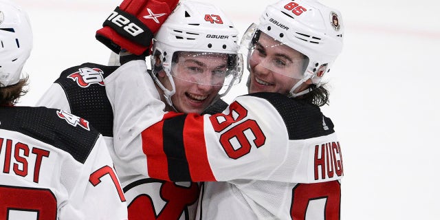 New Jersey Devils defenseman Luke Hughes and brother Jack Hughes celebrate Thursday, April 13, 2023, in Washington.