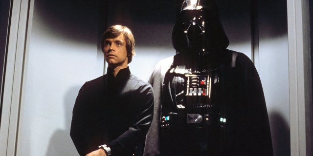 A still from "Star Wars: Episode VI - Return of the Jedi" with Luke Skywalker (Mark Hamill) standing behind Darth Vader