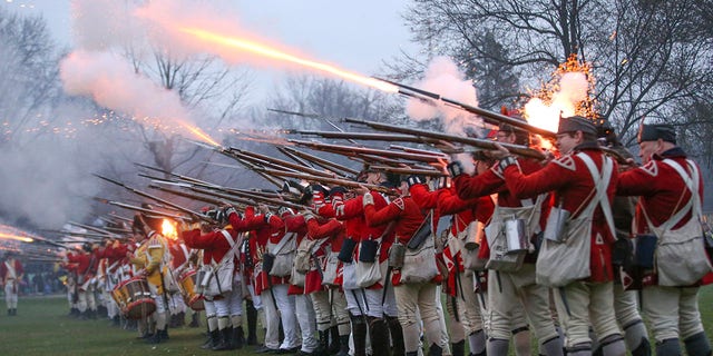 British soldiers fire upon members of the local militia company during the annual re-enactment of the Battle of Lexington on Lexington Common on Monday, April 15, 2019, in Lexington, Massachusetts. 