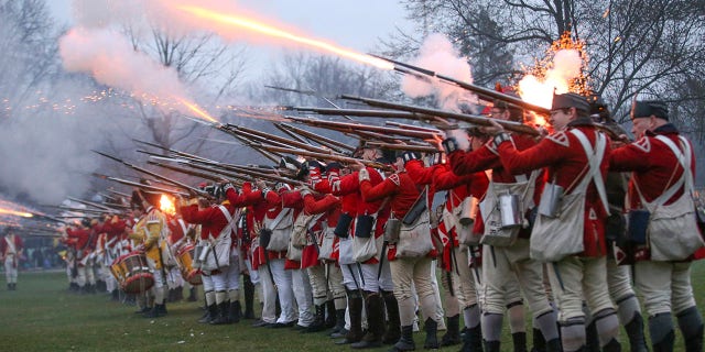 British soldiers fire upon members of the local militia company during the annual re-enactment of the Battle of Lexington on Lexington Common on Monday, April 15, 2019, in Lexington, Massachusetts.