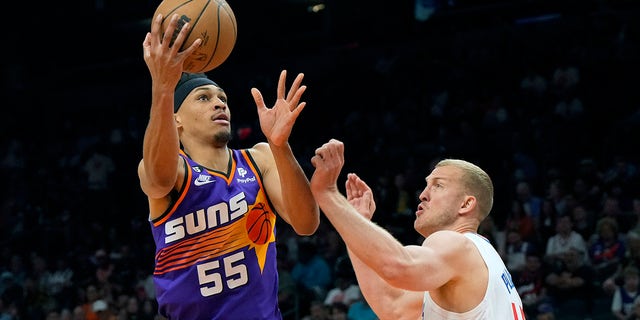 Suns forward Darius Bazley drives around LA Clippers center Mason Plumlee on Sunday, April 9, 2023, in Phoenix.