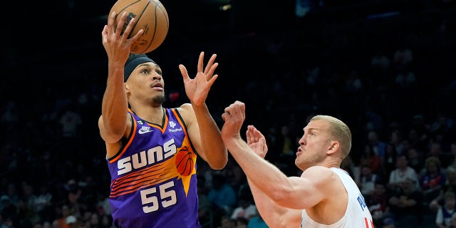 Suns forward Darius Bazley drives around LA Clippers center Mason Plumlee, Sunday, April 9, 2023, in Phoenix.