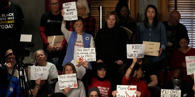 Gun reform and "Tennessee Three" supporters raise signs in the gallery of the House chamber Thursday, April 6, 2023, in Nashville, Tennessee.