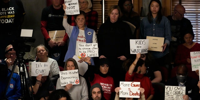Gun reform and "Tennessee Three" supporters raise signs in the gallery of the House chamber Thursday, April 6, 2023, in Nashville, Tennessee.