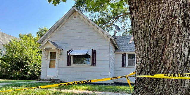 Police tape hangs on a tree outside the home of 53-year-old Michele Ebeling, Aug. 5, 2022, in Laurel, Nebraska.
