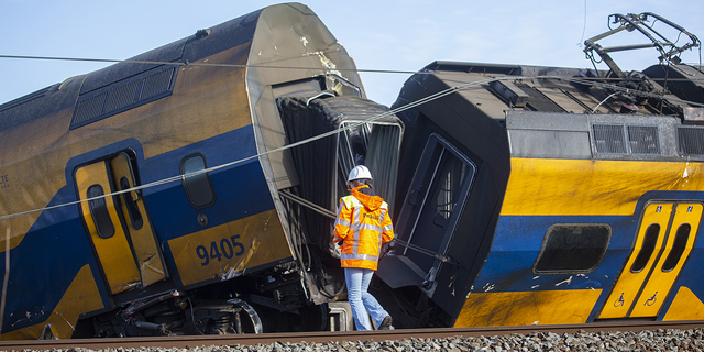 A Dutch railway official inspects the crash scene after a train crashed into a construction crane on April 4, 2023 in Voorschoten, Netherlands.