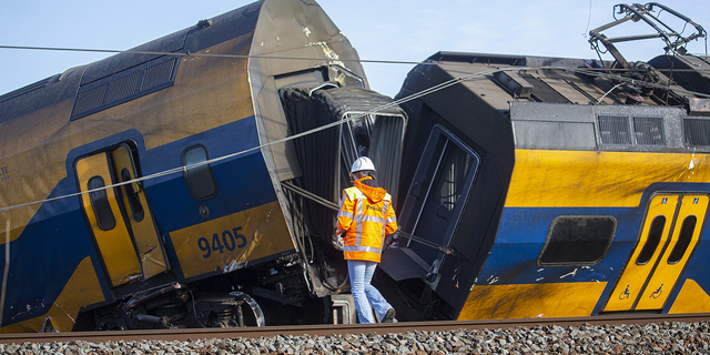 A Dutch railway official inspects the crash scene after a train crashed into a construction crane on April 4, 2023 in Voorschoten, Netherlands.