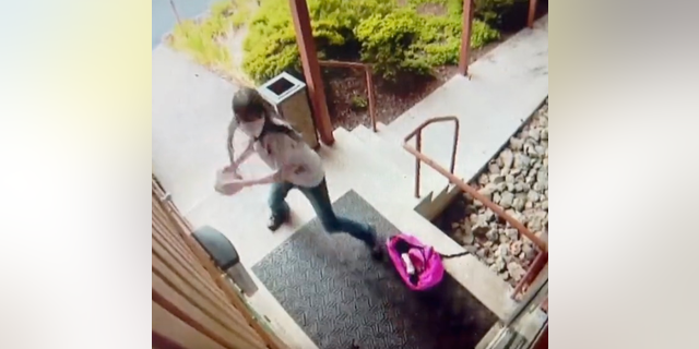 Maeve Nota smashes a glass door at St. Louise Catholic Church in Bellevue, Washington.