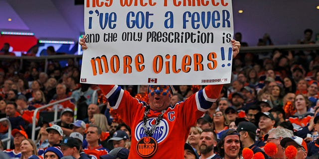 Oilers fan holds a up a sign