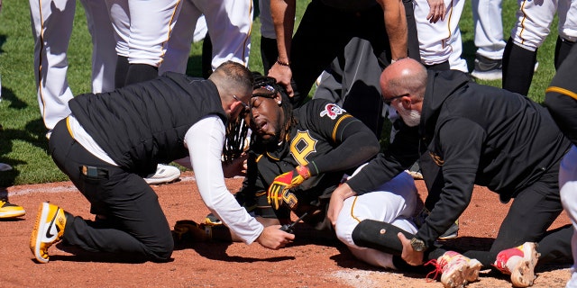 Pittsburgh Pirates' Oneil Cruz, center, is tended to by team trainers after colliding with Chicago White Sox catcher Seby Zavala attempting to score during the sixth inning of a baseball game in Pittsburgh, Sunday, April 9, 2023. A bench clearing brawl ensued as a result of the play. The Pirates won 1-0.
