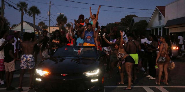 People dancing in the street and on cars as the sun goes down on Tybee Islands Orange Crush