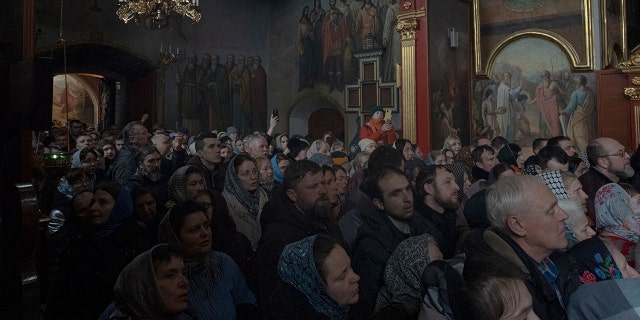 People gather to pray in the Kyiv Pechersk Lavra monastery complex in Kyiv, Ukraine, Wednesday, March 29, 2023.  