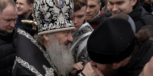 A senior priest of the Ukrainian Orthodox Church walks by a crowd of people and blesses parishioners in the Kyiv Pechersk Lavra monastery complex in Kyiv, Ukraine, Wednesday, March 29, 2023.