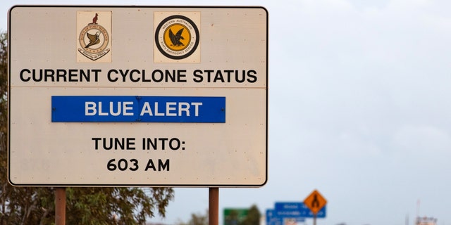A sign showing current hurricane conditions stands next to a highway in Port Hedland, Australia, Thursday, March 21, 2019.  Port Hedland is the nexus of Australia's iron-ore industry. 