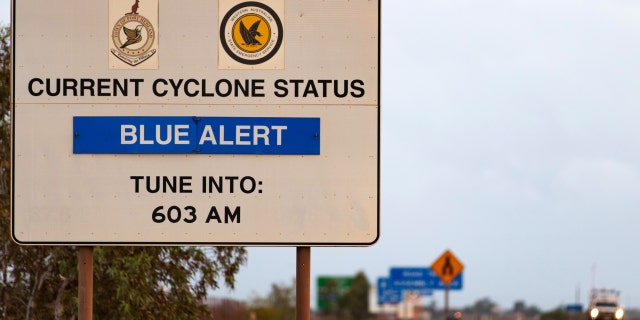 A sign showing the current cyclone status stands next to a highway in Port Hedland, Australia, on Thursday, March 21, 2019. Port Hedland is the nexus of Australia's iron-ore industry. 