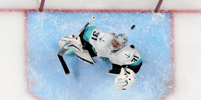 El portero del Seattle Kraken, Philipp Grubauer (31), observa cómo el disco vuela sobre su cabeza durante el primer período del Juego 1 de la serie de playoffs de hockey de la NHL contra Colorado Avalanche, el martes 18 de abril de 2023 en Denver. 