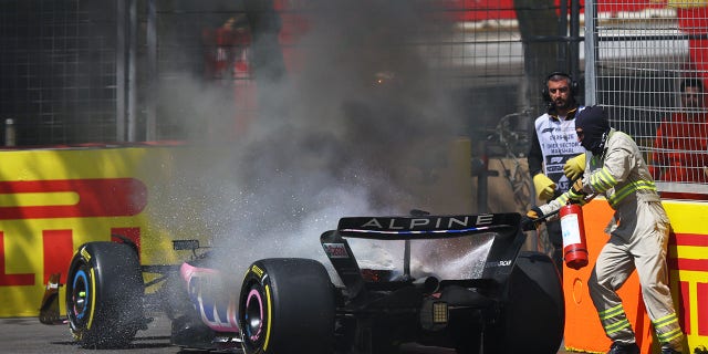 Track officials put out the fire in Pierre Gasly's car 