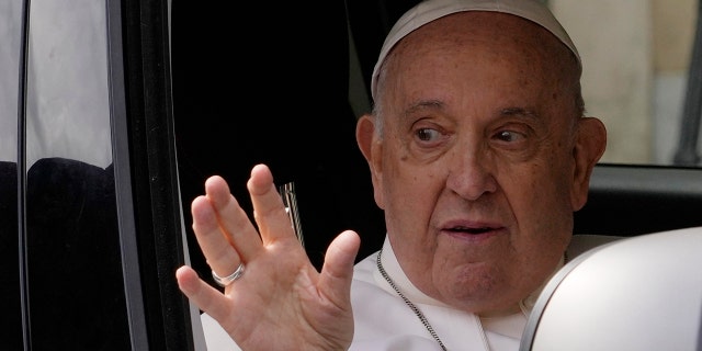 Pope Francis waves from his car as he arrives at the Vatican on Saturday, April 1, 2023, after receiving treatment at the Agostino Gemelli University Hospital for bronchitis, the Vatican said. 