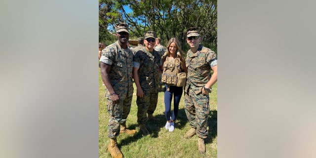 Berkleigh Wright posing for a photo with military servicemen
