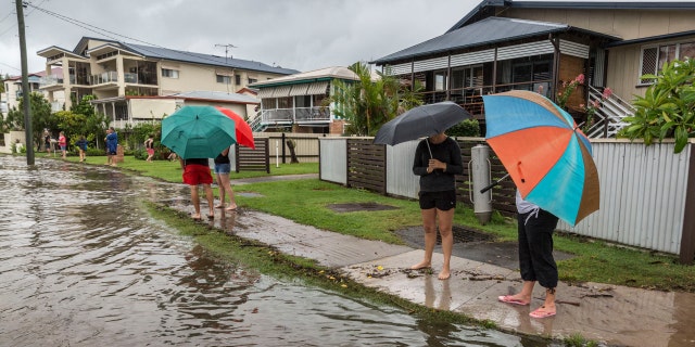 MAROOCHYDORE, AUSTRALIA - FEBRUARY 21: Residents on Bradman Avenue, Maroochydore watch on as the Maroochydore River rises at high tide and threatens their homes after a deluge of rain from the remnants of Cyclone Marcia as it tracks along Australia's Eastern coast on February 21, 2015, in Maroochydore, Australia. 