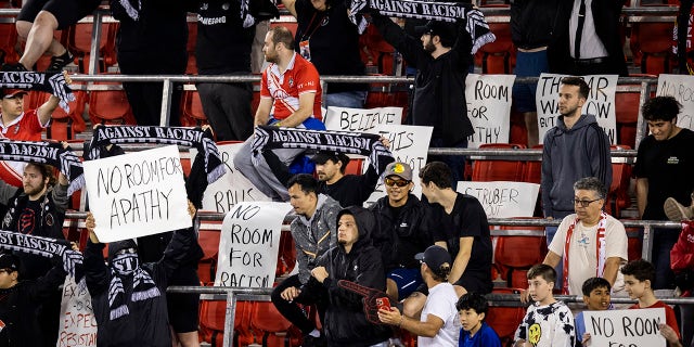 Members of the Viking Army supporters of the New York Red Bulls hold signs and scarves at the start of the Major League Soccer match against Houston Dynamo FC.