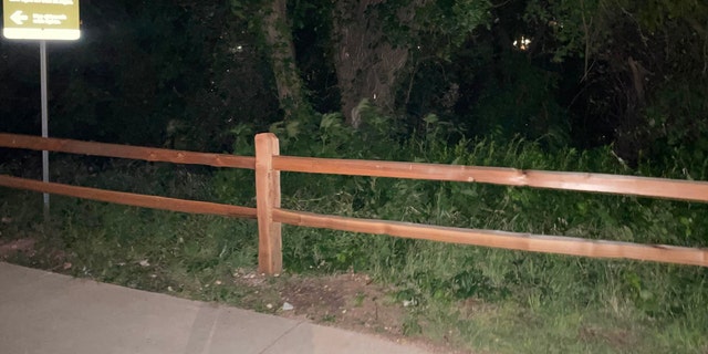 Wooden fencing along the edge of a paved trail