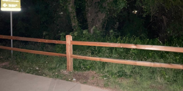 Wooden fencing along the edge of a paved trail