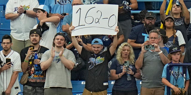 A Tampa Bay Rays fan holds a sign during the ninth inning of the Oakland Athletics game at St. Petersburg on Sunday, April 9, 2023.