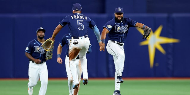 Wander Franco (5) and Manuel Margot (13) of the Tampa Bay Rays celebrate winning a game against the Boston Red Sox at Tropicana Field on April 12, 2023 in St. Petersburg, Florida.
