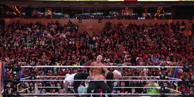 Apr 2, 2023; Inglewood, CA, USA; The Usos (white shirts) interfere in the match between Roman Reigns (black pants) and Cody Rhodes (navy blue pants) during Wrestlemania Night 2 at SoFi Stadium.