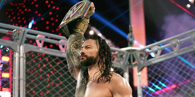 Roman Reigns holds up the WWE Universal Championship after defeating Jey Uso during a match on Oct. 25, 2020, in Orlando, Florida. Reigns and Cody Rhodes will be in the main event of WrestleMania 39 on April 2, 2023, in Los Angeles. 