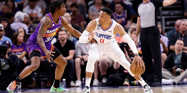 Russell Westbrook #0 of the Los Angeles Clippers posts up on Saben Lee #38 of the Phoenix Suns during the game at Footprint Center on April 09, 2023 in Phoenix, Arizona. The Clippers defeated the Suns 119-114.