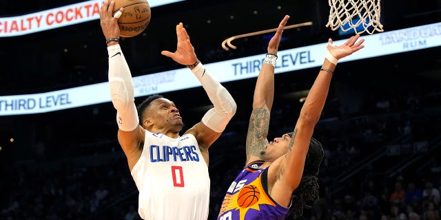 Los Angeles Clippers guard Russell Westbrook, #0, drives on Phoenix Suns guard Damion Lee during the second half of an NBA basketball game, Sunday, April 9, 2023, in Phoenix.