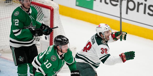Minnesota Wild right wing Ryan Hartman (38) celebrates in front of Dallas Stars' Ty Dellandrea (10) and Radek Faksa (12) after scoring in the second overtime of Game 1 of an NHL hockey Stanley Cup first-round playoff series, Tuesday, April 18, 2023, in Dallas.