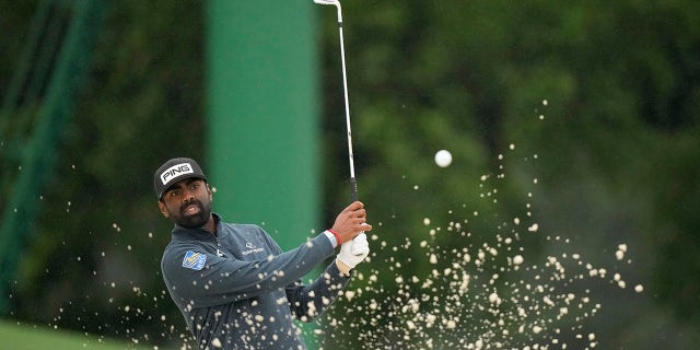 Sahith Theegala hits from the bunker on the 18th hole during the weather delayed second round of the Masters golf tournament at Augusta National Golf Club on Saturday, April 8, 2023, in Augusta, Ga.