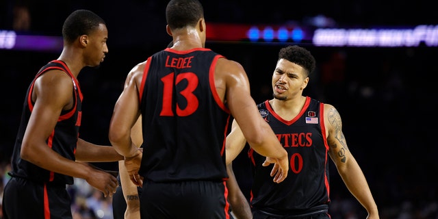 Matt Bradley #20 of the San Diego State Aztecs reacts with teammates during the second half against the Connecticut Huskies during the NCAA Men's Basketball Tournament National Championship game at NRG Stadium on April 3, 2023 in Houston , Texas.