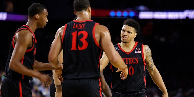 Matt Bradley #20 of the San Diego State Aztecs reacts with teammates during the second half against the Connecticut Huskies during the NCAA Men's Basketball Tournament National Championship game at NRG Stadium on April 3, 2023 in Houston , Texas.