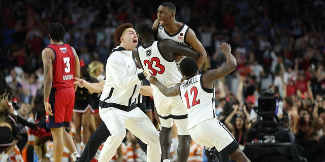 Lamont Butler of the San Diego State Aztecs celebrates with teammates after making a game-winning basket to defeat the Florida Atlantic Owls 72-71 during the Final Four semifinal game at NRG Stadium on April 1, 2023, in Houston, Texas.
