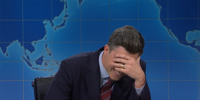 Colin Jost put his hand to his face, realizing that Michael Che had made a joke on him.