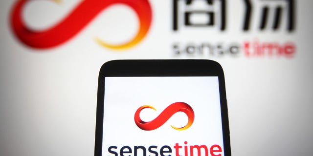 In this photo illustration, SenseTime logo is seen displayed on a smartphone and a PC screen.Â