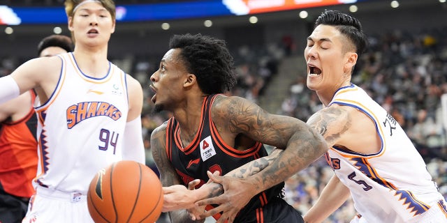 Antonio Blakeney of Jiangsu Dragons vies for the ball against the Sharks in east China's Shanghai, April 9, 2023.