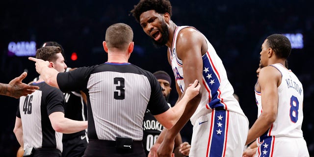 Joel Embiid talks to a referee