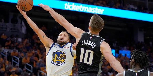 Stephen Curry shoots over Domantas Sabonis