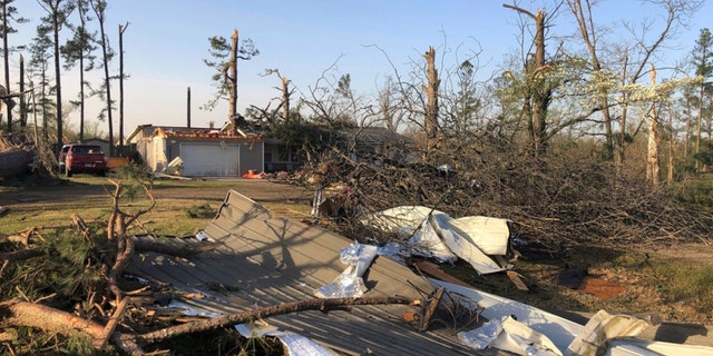 Debris covers the ground around a home damaged by severe weather in Wayne, Arkansas, on Saturday, April 1, 2023.  